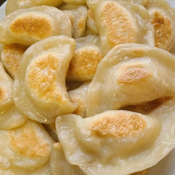 A pile of golden pierogies glistening fresh out of the fryer.